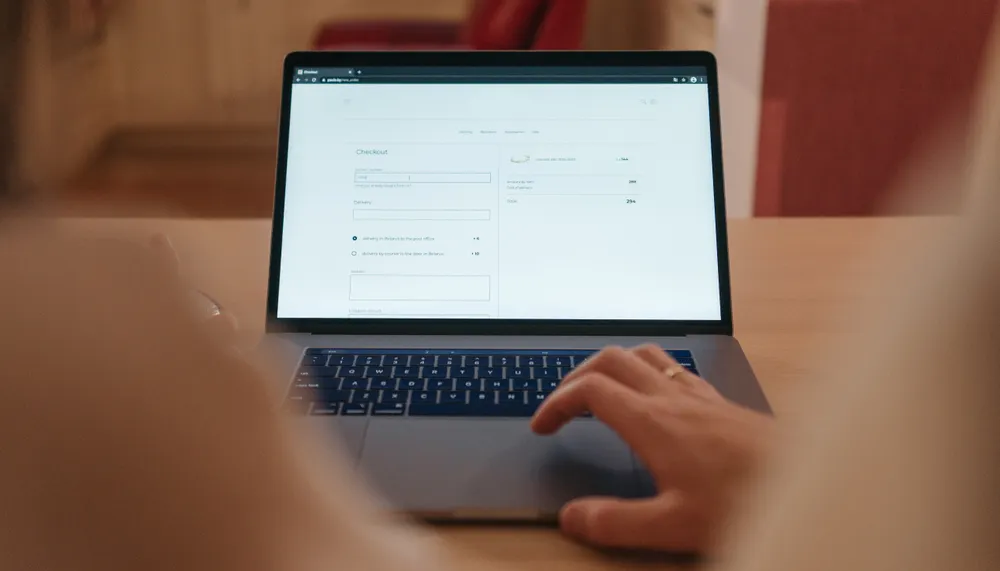 Person entering information on an ecommerce checkout form on a laptop.