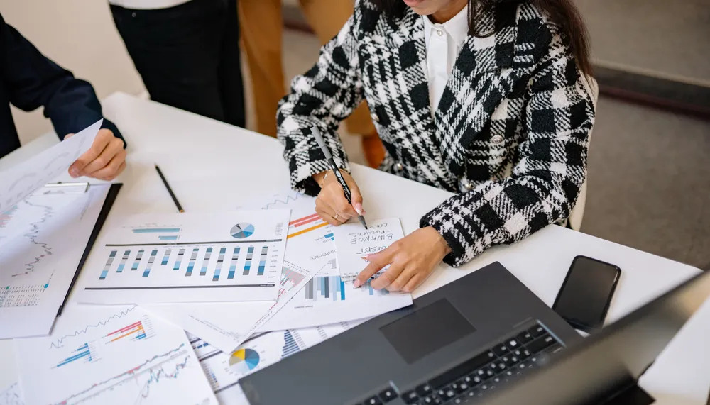 Multiple merchant processing statements being consolidated for analysis.